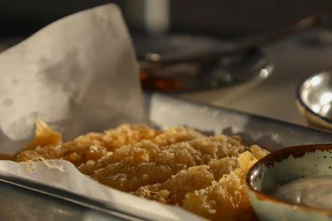 Crispy fried dish served on a platter with dipping sauce and small plates o.. Foto stock