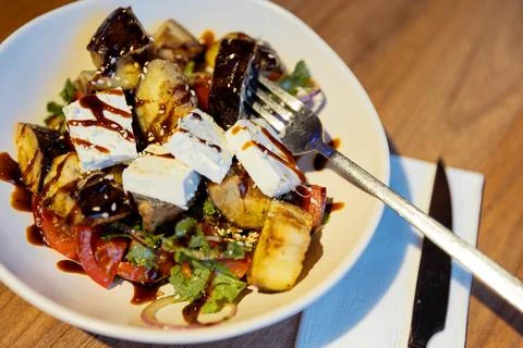 Crispy fried eggplant salad with cherry tomatoes, brined white cheese, fres.. Stock Photos