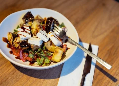 Crispy fried eggplant salad with cherry tomatoes, brined white cheese, fres.. Stock Photos