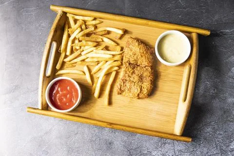 Crispy Fried Fish and Chips with mayo dip and tomato sauce served in wooden.. Foto stock
