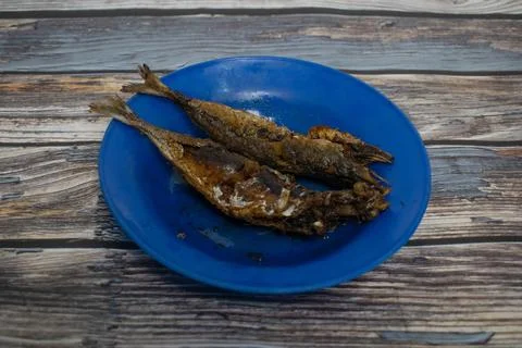 Crispy fried fish displayed on a bright blue plate Stock Photos