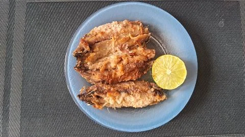 Crispy fried fish fillets served with a fresh lime slice Stock Photos