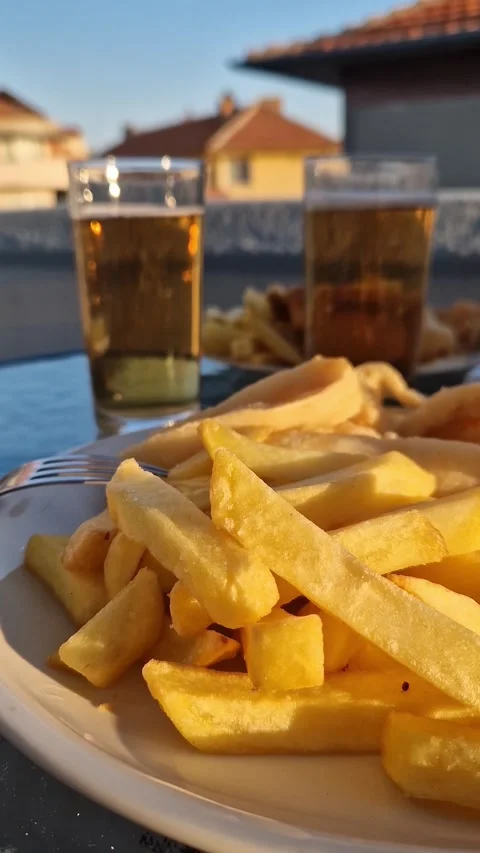 Crispy fried fish, golden potatoes and a cold beer for two Stock-Footage 342942861