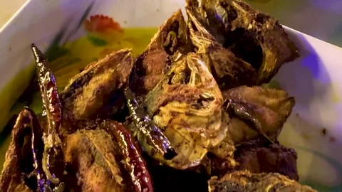 Crispy fried fish served with roasted dried red chilies Stock Footage 340581184