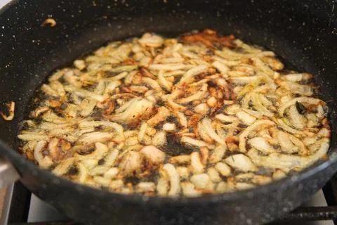 Crispy Fried Onion Bits with oil in the pan. Deep fried onion. Homemade fry.. Stock Photos