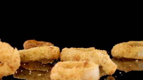 Crispy Fried Onion Rings Dropping Onto Black Surface Stock Footage 313096238