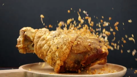 Crispy fried pork knuckle falling in slow motion on black background Stock Footage 131692156