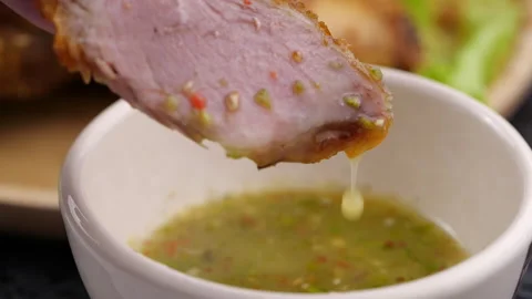 Crispy fried pork knuckle sliced dipping seafood sauce in slow motion Stock Footage 131692680
