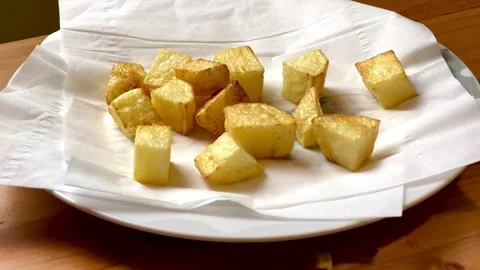 Crispy fried potato cubes on white tissue paper Video stock 334678119