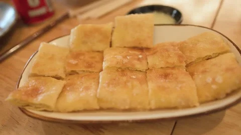 Crispy Fried Roti Pancake with Egg on a White Plate Stock Footage 342574254
