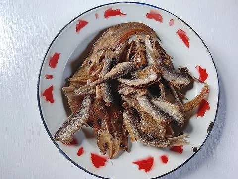 Crispy Fried Small Fish on Enamel Plate Traditional Indonesian Food Stock Photos
