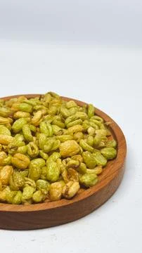 Crispy fried soybeans served on a round wooden plate on a desk Stock Photos