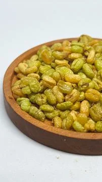 Crispy fried soybeans served on a round wooden plate on a desk Stock Photos