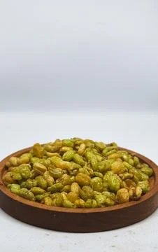Crispy fried soybeans served on a round wooden plate on a desk Stock Photos