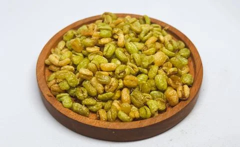 Crispy fried soybeans served on a round wooden plate on a desk Stock Photos