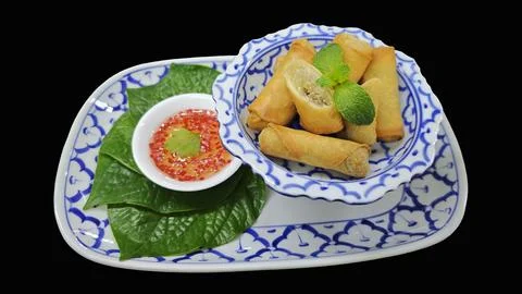 Crispy fried spring rolls with sweet chili sauce isolated on black background. Stock Photos
