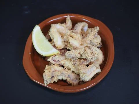 Crispy Fried Squid served in a dish isolated on dark background top view Foto stock