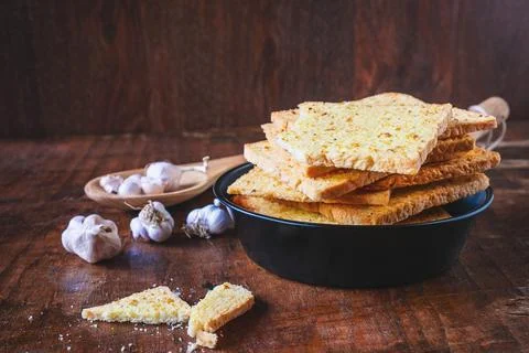 .Crispy garlic bread on a wooden table Stock Photos