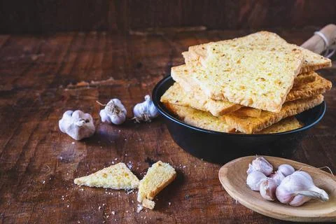 .Crispy garlic bread on a wooden table Stock Photos