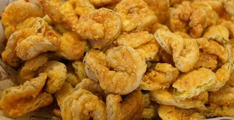 Crispy, golden-brown deep-fried pickle slices showing a textured cornmeal b.. Stock Photos