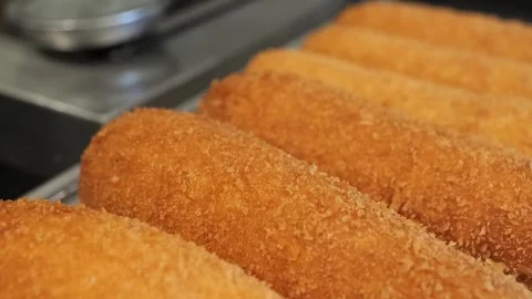 Crispy, Golden-Brown Korean Corn Dogs Freshly Fried on a Cooling Rack Stock Footage 331955748