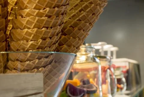Crispy golden empty ice cream cones one over another, in a candy shop, during Stock Photos