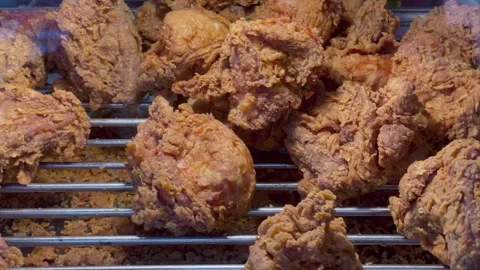 Crispy golden fried chicken displayed on rack in food stall 스톡 동영상 343174223