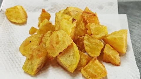Crispy golden fried potato chunks on a paper towel. Vidéo 344559089