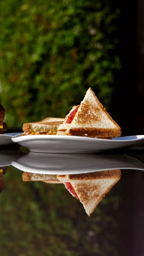 Crispy grilled beef burger and delicious ham sandwich on a glass table. Stock Footage 295815940