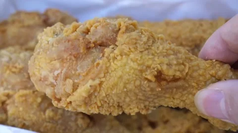 Crispy Korean Fried Chicken Drumstick Held by Hand - Stock Footage Close-up Video stock 343026993