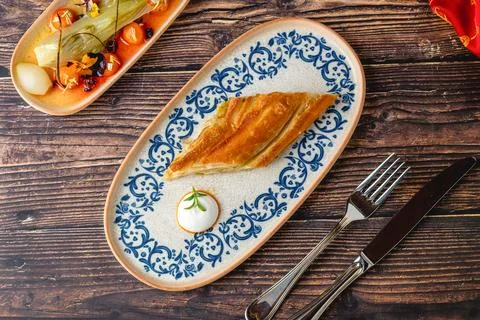 Crispy layered Turkish borek slice with yogurt dip Stock Photos