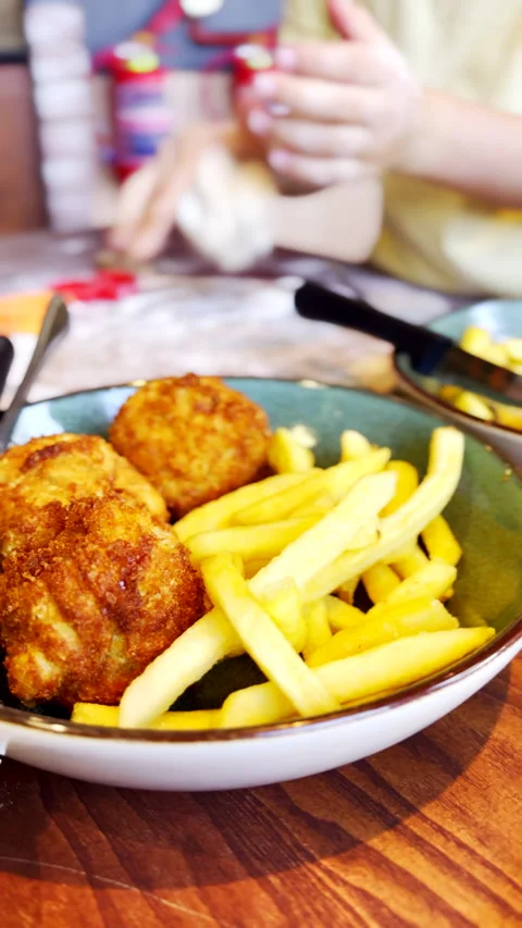 Crispy mac and cheese balls with deep fried fries as kid plays with dough to Stock Footage 328667664