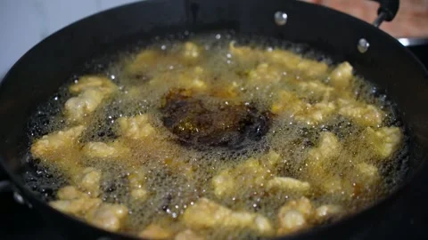 The crispy meat is being fried in the iron pot. Stock Footage 309538531
