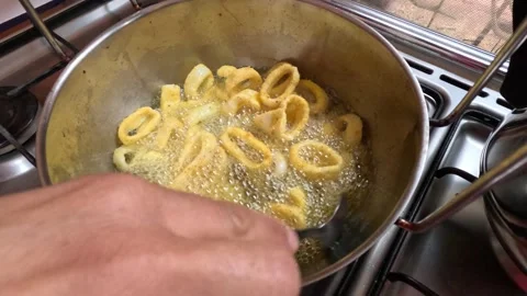 Crispy Moroccan calamari rings are deep-fried in bubbling oil Stock Footage 329162284