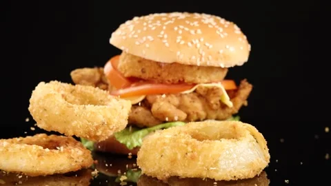 Crispy Onion Rings Dropping Beside Fried Chicken Burger Stock Footage 313186019