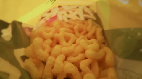 Crispy Orange Cheesy Puff Snacks Piled Inside an Open Snack Bag Stock Footage 341993539