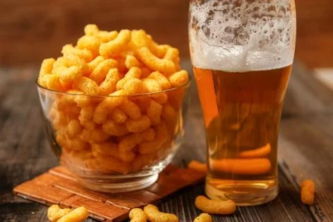 Crispy peanut puffs or flips snacks and cup of beer Stock Photos