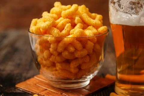 Crispy peanut puffs or flips snacks and cup of beer Stock Photos
