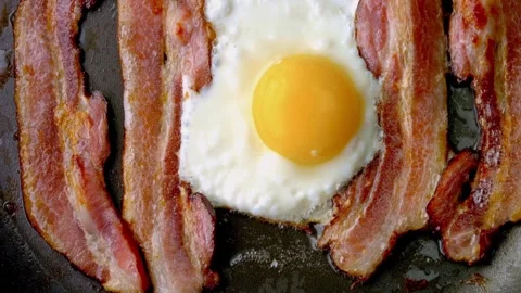 Crispy pork bacon and egg being cooked with Splashes of sizzling oil. 스톡 동영상 334643396