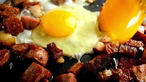 Crispy pork bacon and egg being cooked with Splashes of sizzling oil. 스톡 동영상 334643527