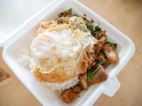 Crispy Pork Basil with Fried Egg in Foam Box Takeaway. Foto stock