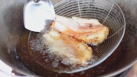 Crispy pork belly fried in hot oil in a pan on the gas stove for breakfast Stock-Footage 174029136