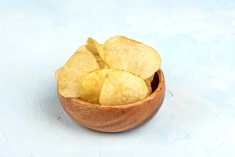 Crispy potato chips. Blue background with place for text. Stock Photos