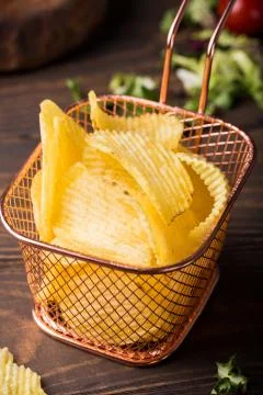 Crispy potato chips in copper basket Stock-Fotos