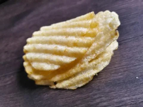 Crispy potato chips on dark background Stock Photos