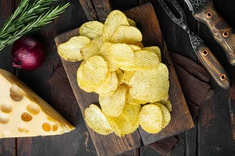 Crispy potato chips, on old dark wooden table , top view flat lay Stock Photos