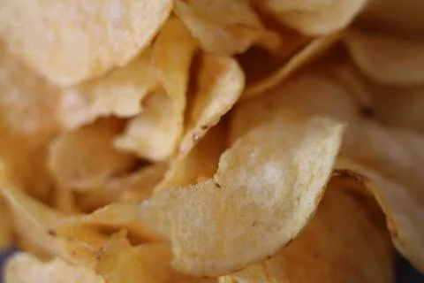 Crispy potato chips served in a close-up view showcasing texture and golden.. Stock Photos