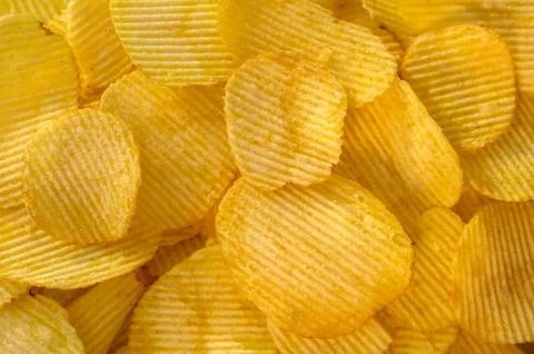 Crispy potato chips snack texture background top view Stock Photos