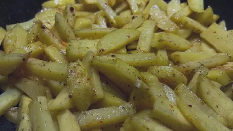 Crispy potatoes are fried in hot boiling oil in the kitchen. Close-up of French Stock Footage 251536778