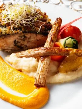 Crispy roasted root vegetable rests beside creamy mash 库存照片